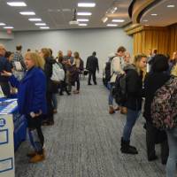 An aisle of booths with several different majors at the Academic Major Fair.